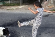 INUIT GIRLPLAYING BALL WITH HER DOG