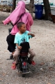 Small Boy riding on his Mother's electric scooter