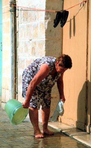 Woman Cleaning Her Steps in Marsaxlokk 